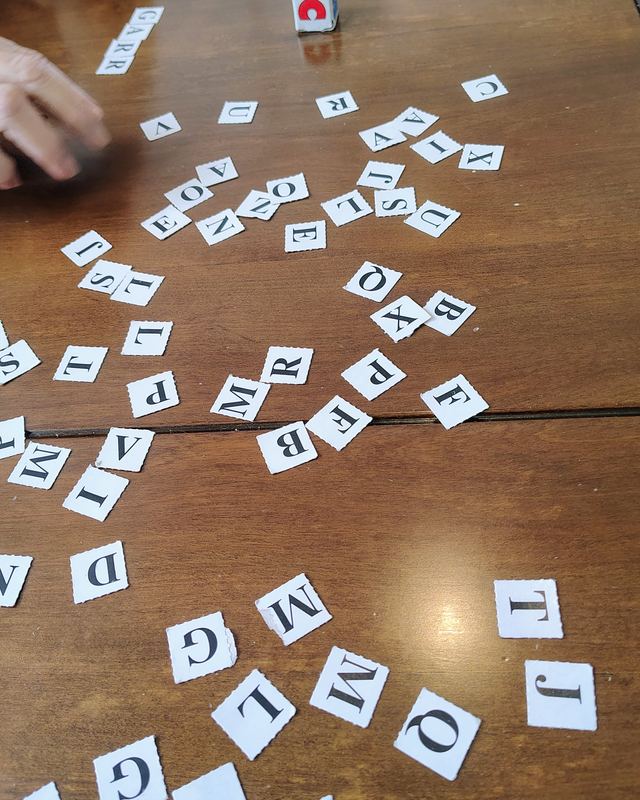 Letras recortadas espalhadas sobre a mesa para formar palavras